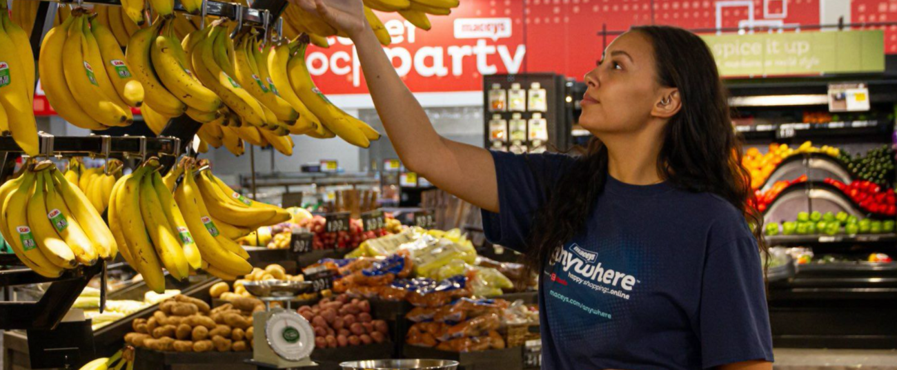 woman-wearing-maceys-shirt-shopping-for-bananas