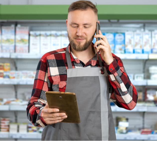 supermarket-clerk-uses-tablet-manage-inventory